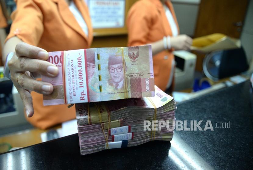 Transaksi Mata Uang Lokal. Petugas menghitung mata uang Rupiah di jasa penukaran uang, Jakarta, Senin (11/12).