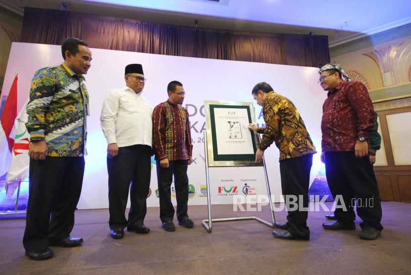 Direktur Pemberdayaan Zakat dan Wakaf Kementerian Agama RI Muhammad Fuad Nasar menandatangani mockup pada Peluncuran Buku Saku Prosedur Pengajuan Laegalitas Laz pada acara Indonesia Zakat Summit yang digelar Forum Zakat (FOZ), di Hotel Horison, Kota Bandung, Kamis (20/12).