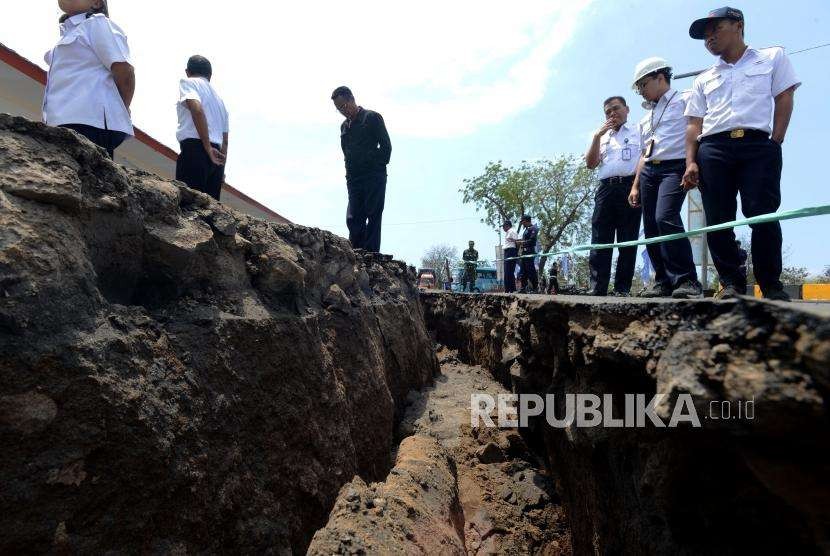 Petugas melihat kondisi area parkir ruang tunggu yang retak akibat gempa di Pelabuhan Kayangan, Lombok Timur, NTB, Selasa (21/8).