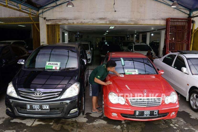 Pegawai membersihkan mobil bekas yang dijual di bursa mobil Geraldi Auto, Pondok Bambu, Jakarta, Kamis (11/10).