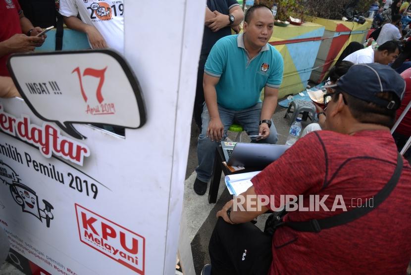 Petugas KPUD DKI Jakarta membantu penegcekan DPT warga saat Hari Bebas Kendaraan Bermotor di Kawasan Bundaran HI, Jakarta, Ahad (21/10).