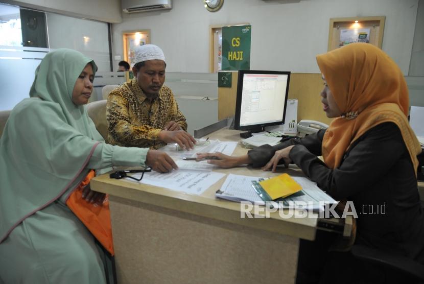 Petugas Bank Mandiri Syariah melayani calon jemaah haji yang melakukan pelunasan Biaya Penyelenggaran Ibadah Haji (BPIH) di Kantor Cabang Mandiri Syariah.(Republika/Edwin Dwi Putranto)