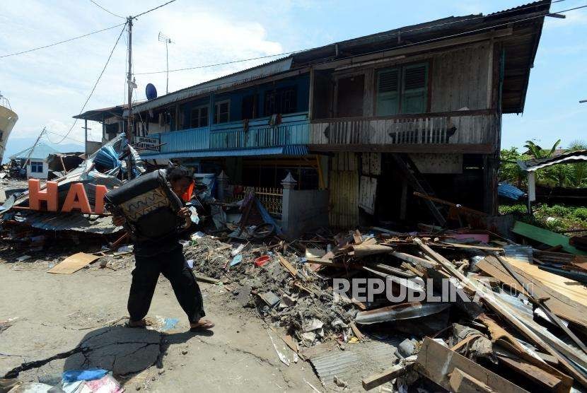 Sejumlah warga menyelamatkan barang berharga pasca bencana alam gempa bumi dan tsunami di Pelabuhan Wani, Palu, Sulawesi Tengah, Kamis (4/10).