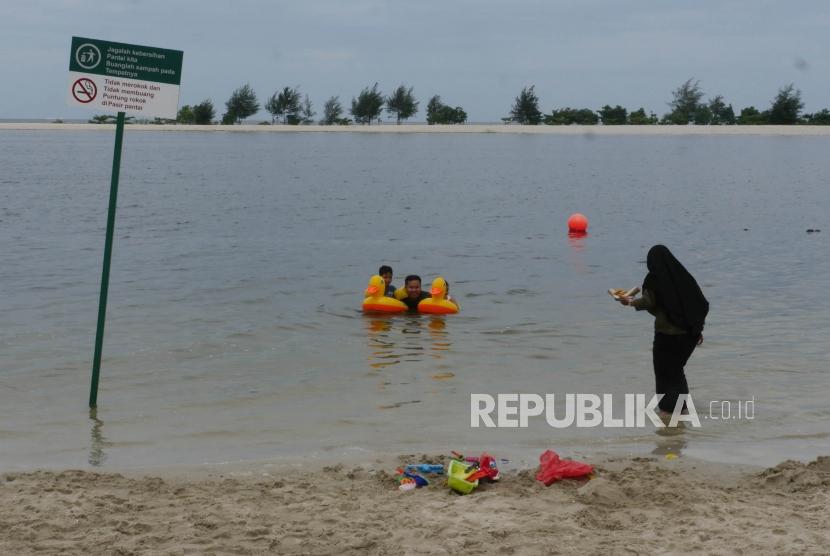 Pengunjung bersama anak-anaknya berenang di pinggiran pantai Taman Impian Jaya Ancol Jakarta (ilustrasi)