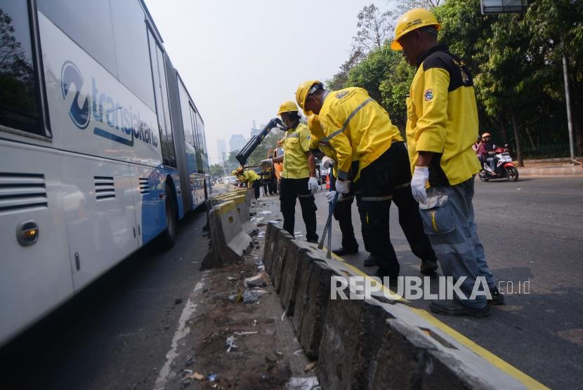 Petugas Bina Marga merapikan pembatas jalur transjakarta pasca aksi 24 September 2019 di Gedung DPR/MPR Senayan, Jalan Gatot Soebroto, Jakarta, Rabu (25/9/2019).