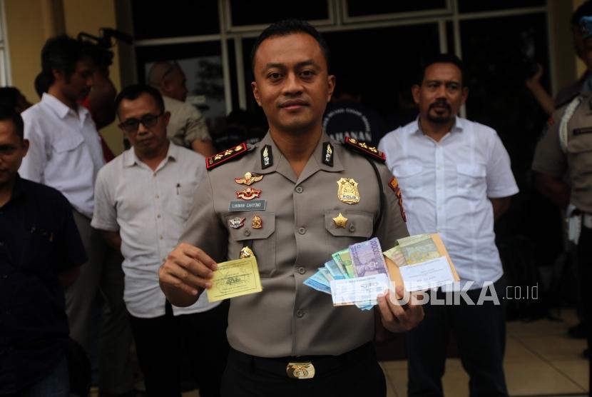 Kapolsek Metro Tanah Abang AKBP Lukman Cahyono memperlihatkan barang bukti karsis dan uang saat rilis kasus retribusi dan parkir liar di Polsek Metro Tanah Abang, Jakarta, Senin (4/6).