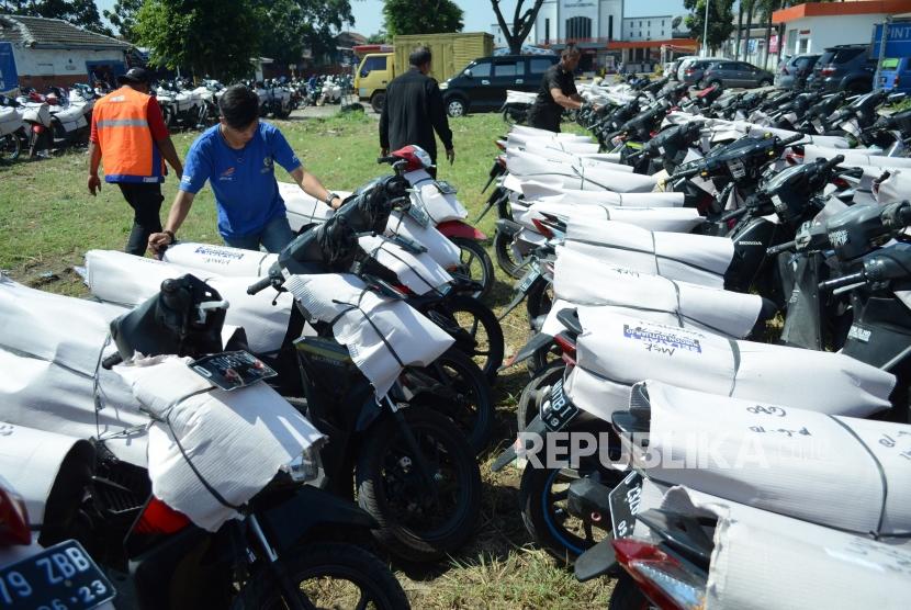 Sejumlah petugas merapikan ratusan sepeda motor milik pemudik yang akan dikirim dengan kereta api (KA), di tempat pengiriman barang Lintas Nusantara Perdana, di Stasiun Kiaracondong, Kota Bandung, Ahad (10/6).