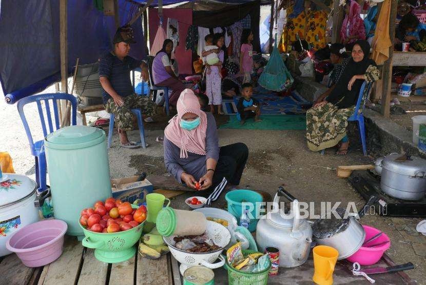 Seorang ibu mempersiapkan bahan makanan untuk dimasak di dapur umum darurat untuk keluarganya di tempat pengungsian Duyu, Palu Barat, kecamatan Tatanga, Selasa (9/10).