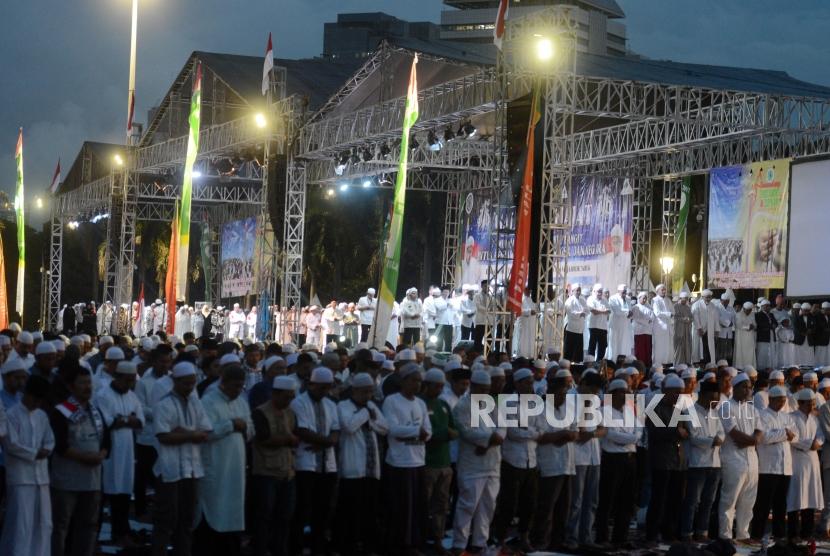 Shalat Maghrib Berjamaah. Sejumlah umat muslim melaksanakan shalat Maghrib berjamaah di Monas, Jakarta, Kamis (21/2).