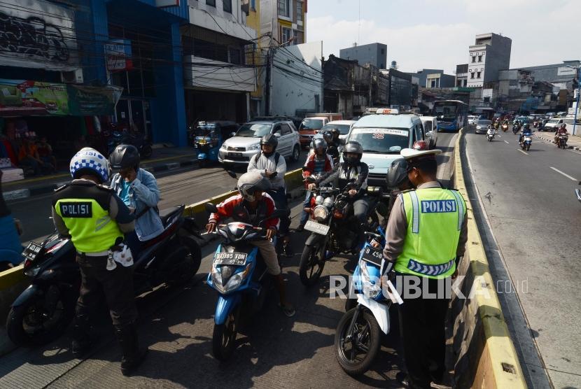Penindakan Pemotor di Jalur Busway.Sejumlah personel Polisi lalu lintas melakukan penindakan terhadap pengendara motor yang melintasi jalur Busway di Jatinegara Barat,Jakarta Timur, Kamis (11/7).