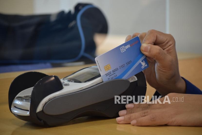 Petugas melayani transaksi nasabah di kantor layanan BRI Syariah, Jakarta, Rabu (24/10).