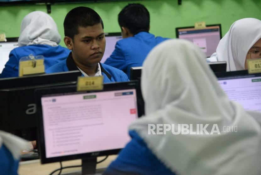 Sejumlah siswa mengikuti Ujian Nasional Berbasis Komputer (UNBK) di Sekolah Menengah Kejuruan (SMK) Negeri 47 Jakarta, Senin (25/3).