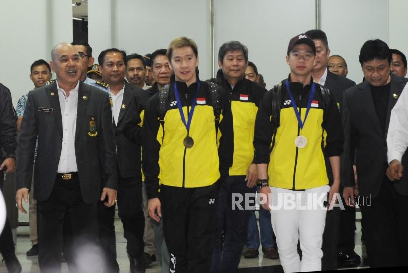 Pebulu tangkis ganda putra Indonesia Kevin Sanjaya Sukamuljo  dan Marcus Fernaldi Gideon (tengah) tiba di Bandara Internasional Soekarno Hatta, Tangerang, Banten, Selasa (20/3).