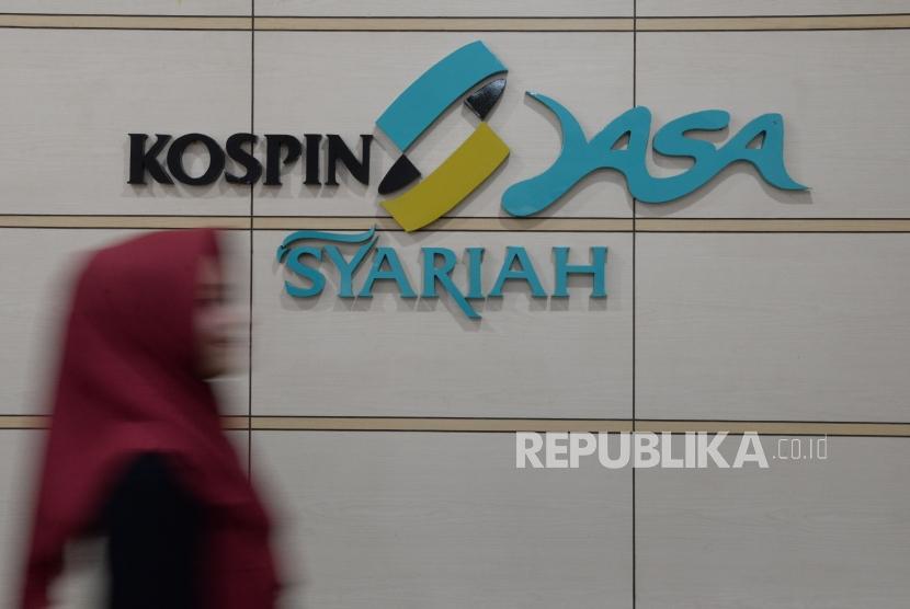 Petugas melintas didekat logo Koperasi Simpan Pinjam (Kospin) Jasa Syariah, Jakarta,Kamis (31/1).