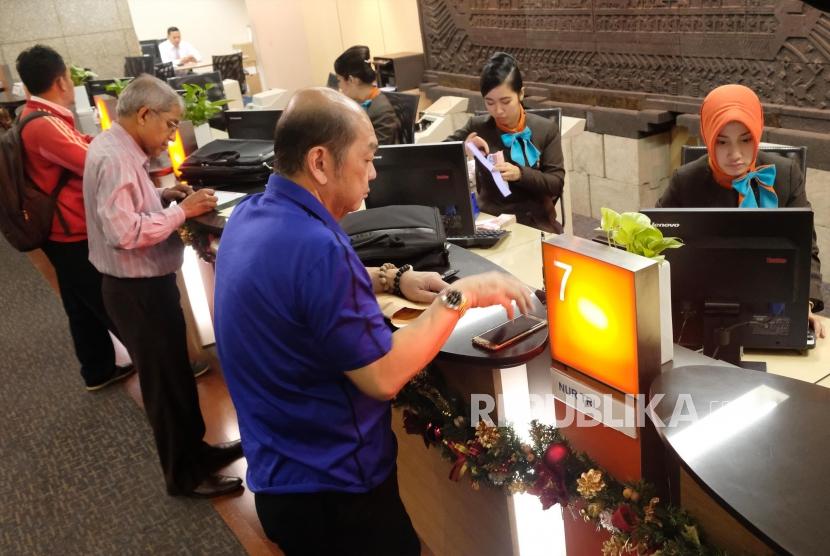 Aktivitas transaksi perbankan di banking hall BNI, Jakarta, Senin (27/11).