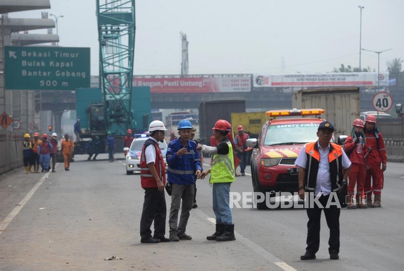 Petugas  mengevakuasi crane yang roboh di KM 15 Tol Jakarta-Cikampek di Wilayah Kota Bekasi, Jawa Barat, Kamis (16/11).