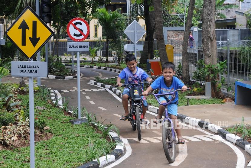 Anak-anak bermain sepeda di taman lalu lintas RPTRA Kebon Pala, Jakarta, Selasa (27/2).