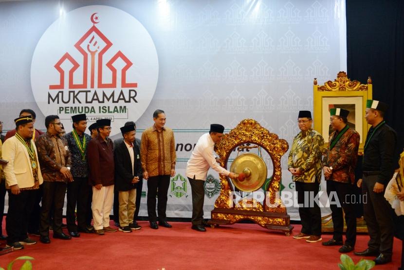 Wakil Ketua Dewan Masjid Indonesia Syafruddin (keempat kanan) disaksikan Menteri Komunikasi dan Informatika Rudiantara (ketiga kanan) memukul gong sebagai tanda dibukanya acara Muktamar Pemuda Islam di Hotel Kartika Chandra, Jakarta, Kamis (4/4).