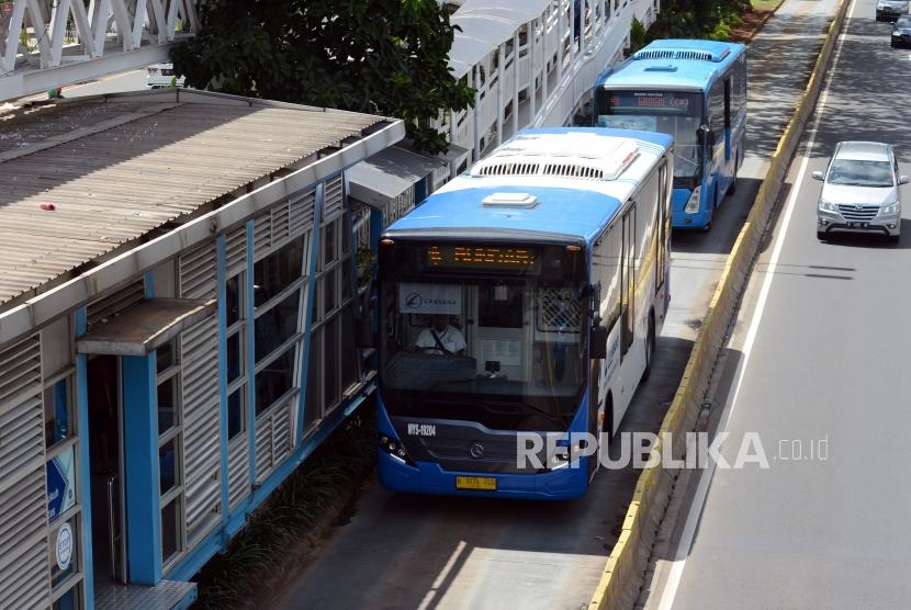 Bus Transjakarta saat akan mengangkut penumpang di Halte Dukuh Atas, Jalan Jenderal Sudirman, Jakarta, Kamis (3/1).