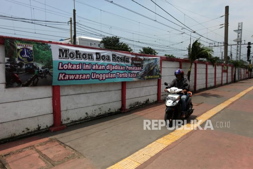 Pengendara motor melintas ditrotoar kawasan Jatinegara, Jakarta, Jumat (23/3).