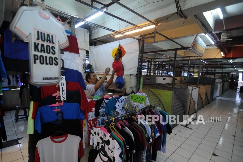 Pedagang merapihkan barang dagangannya disamping kios-kios yang tutup di Blok G Pasar Tanah Abang, Jakarta Pusat, Jumat (17/11).