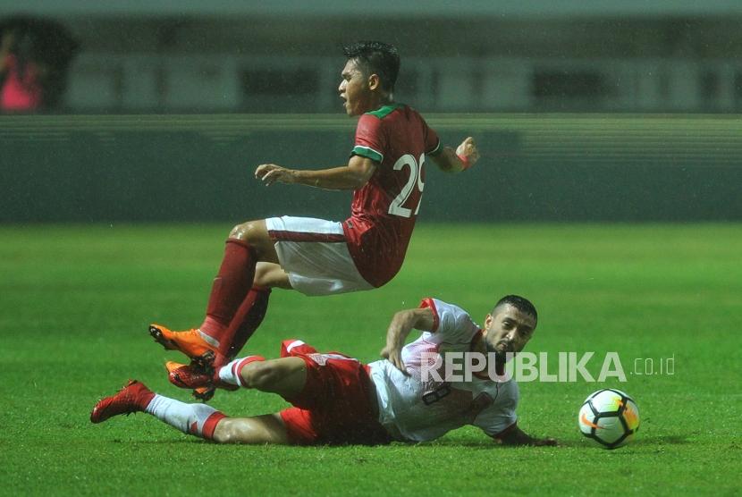 Gelandang Timnas Indonesia Septian David Maulana mendapat hadangan dari pemain Bahrain Mohamed Marhoon dalam laga PSSI Anniversary Cup 2018 di Stadion Pakansari, Cibinong, Bogor, Jumat (27/4) malam.
