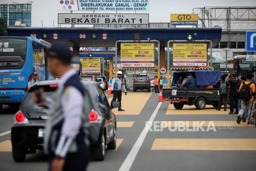 Kendaraan mobil dengan nomor polisi ganjil memutar balik saat hari pertama pemberlakuan sistem ganjil genap di Gerbang Tol Bekasi Barat 1, Bekasi, Jawa Barat, Senin (12/3).