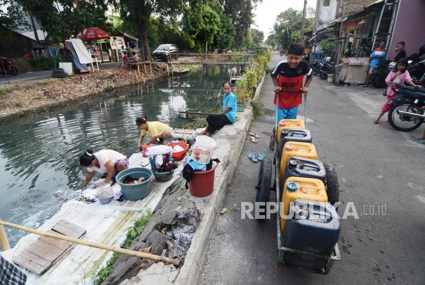 Kurangnnya Pasokan Air Bersih. Sejumlah warga membawa dirigen air bersih di aliran Kali Maja daerah Kalideres, Jakarta Barat, Senin (24/6).