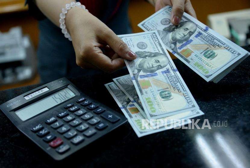 Petugas menghitung uang pecahan dolar Amerika Serikat di gerai penukaran mata uang asing. ilustrasi