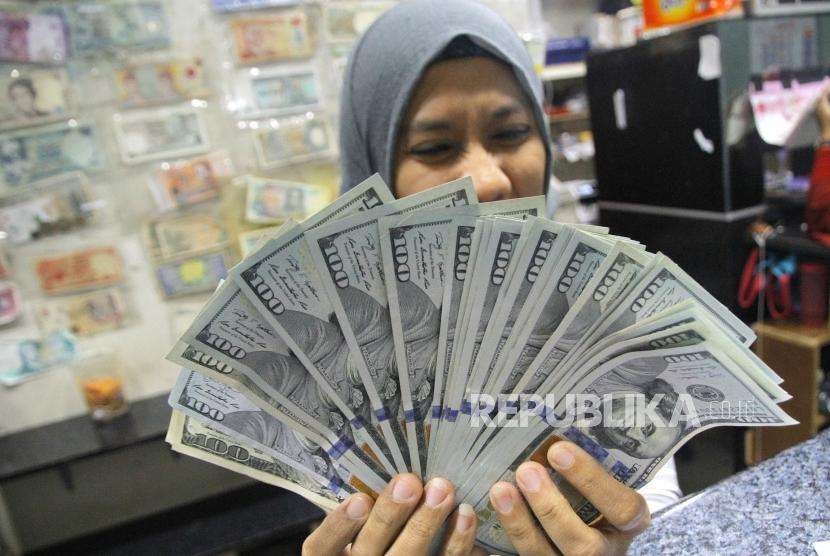 Menukarkan Dolar AS. Petugas menghitung mata uang Dolar As warga saat menukarkan mata uang di jasa penukaran mata uang, Jakarta, Rabu (5/9).
