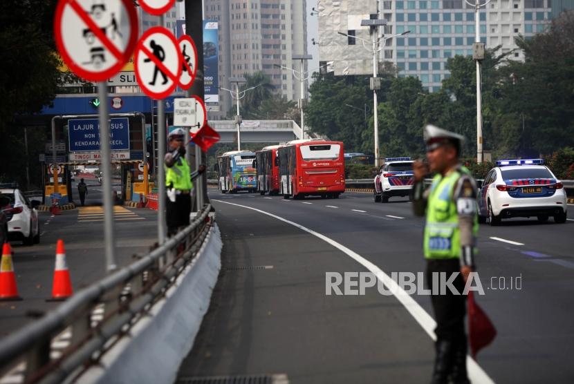 Polisi bersama iring-iringan bus kontingen atlet dari Wisma Atlet Kemayoran menuju komplek Gelora Bung Karno melintas saat simulasi rekayasa lalu lintas di ruas tol dalam kota kawasan Slipi, Jakarta, Rabu (1/8).