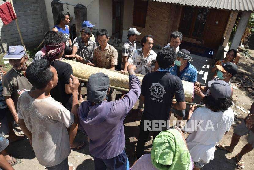 Warga membawa korban meninggal akibat gempa bumi menuju mobil jenazah di Kecamatan Pemenang, Lombok Utara, Nusa Tenggara Barat, Selasa (7/8).