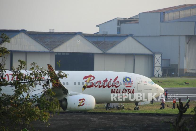 Petugas memeriksa pesawat Batik Air Malaysia yang gagal lepas landas karena keluar landasan pacu, di Bandara Husein Sastranegara, Kota Bandung, Kamis (20/6).