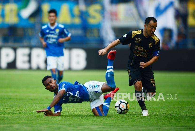 Bek Persib Ardhi Idrus dilanggar gelandang Sriwijaya FC Yu Hyunkoo pada pertadingan Gojek Liga1 2018 di Stadion Gelora Bandung Lautan Api (GBLA) di Bandung, Sabtu (4/7).