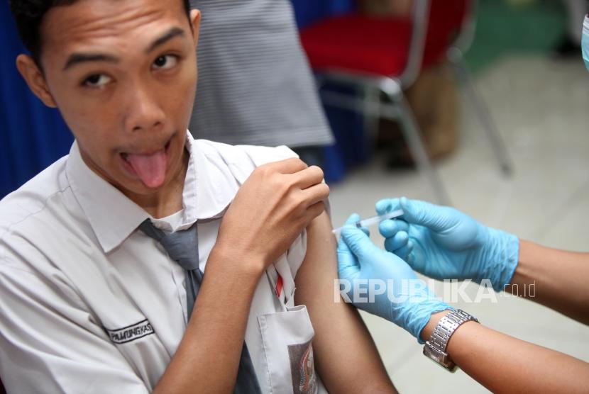 Seorang siswa berekspresi saat diimunisasi difteri pada sosialisasi komitmen pelaksaan kegiatan Outbreak Response Immunization (ORI) Difteri di Sekolah SMAN 33 Jakarta, Jalan Kamal Raya, Jakarta Barat, Senin (11/12).