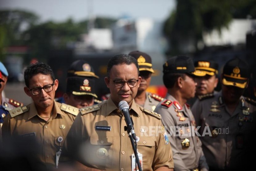 Gubernur DKI Jakarta Anies Baswedan (tengah) bersama Wakil Gubernur DKI Jakarta Sandiaga Salahudin Uno (kiri)..