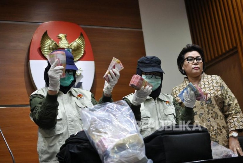 Wakil Ketua KPK Basariah Pandjaitan (kanan) bersama penyidik memperlihatkan barang bukti hasil OTT Bupati Nganjuk saat konferensi pers di Gedung KPK, Jakarta, Kamis (26/10).