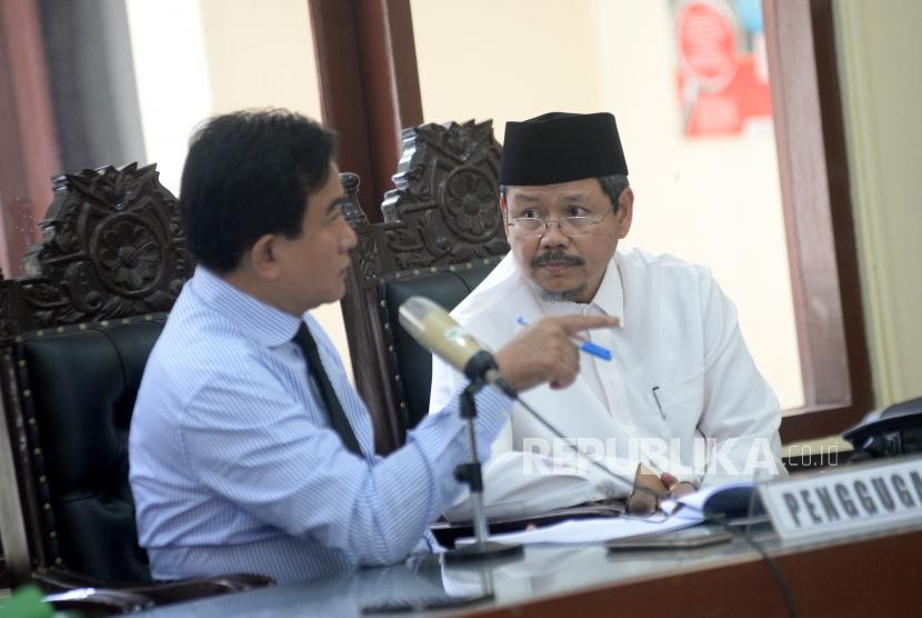 Kuasa Hukum HTI Yusril Ihza Mahendra berbincang dengan mantan juru bicara HTI Ismail Yusanto dalam sidang perdana gugatan HTI terhadap langkah pemerintah yang mencabut status badan hukumnya di PTUN Jakarta, Kamis (23/11).