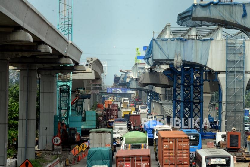 Sejumlah kendaraan melintas di dekat proyek pembangunan jalan tol layang Jakarta-Cikampek dan LRT di Bekasi, Jawa Barat, Selasa (23/4).