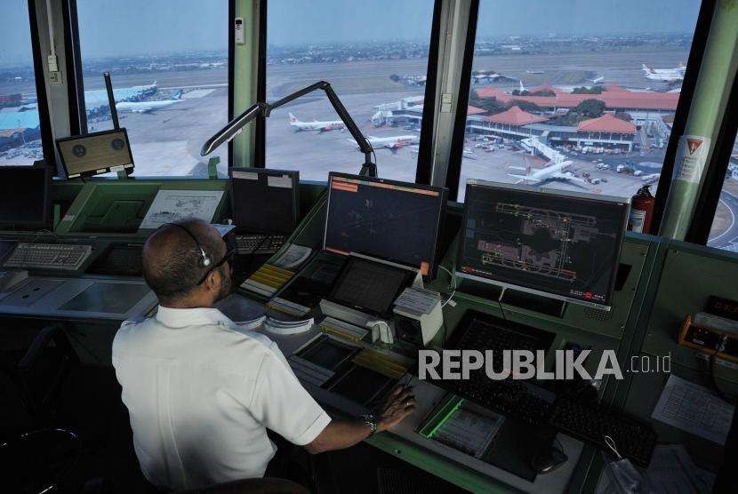 Pemandu lalu lintas udara AirNav Indonesia memantau pergerakan lalu lintas udara pesawat melalui layar radar di menara kontrol (Air Traffic Controller/ATC) Bandara Internasional Soekarno-Hatta, Tangerang, Banten, Senin (6/8).