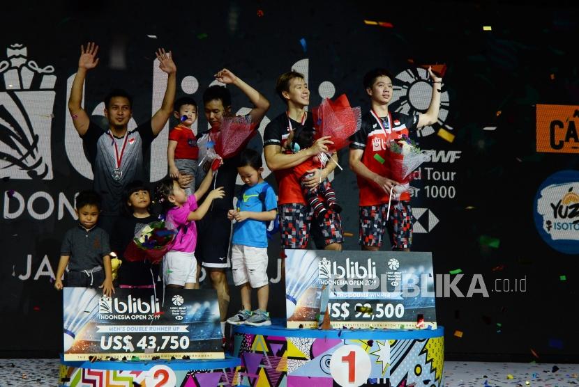 Ganda putra Indonesia Marcus Fernaldi Gideon (kiri) dan Kevin Sanjaya Sukamuljo berada di atas podium setelah bertanding mengalahkan ganda putra Indonesia Mohammad Ahsan dan Hendra Setiawan pada final Blibli Indonesia Open 2019 di Istora Gelora Bung Karno, Jakarta, Ahad (21/7).
