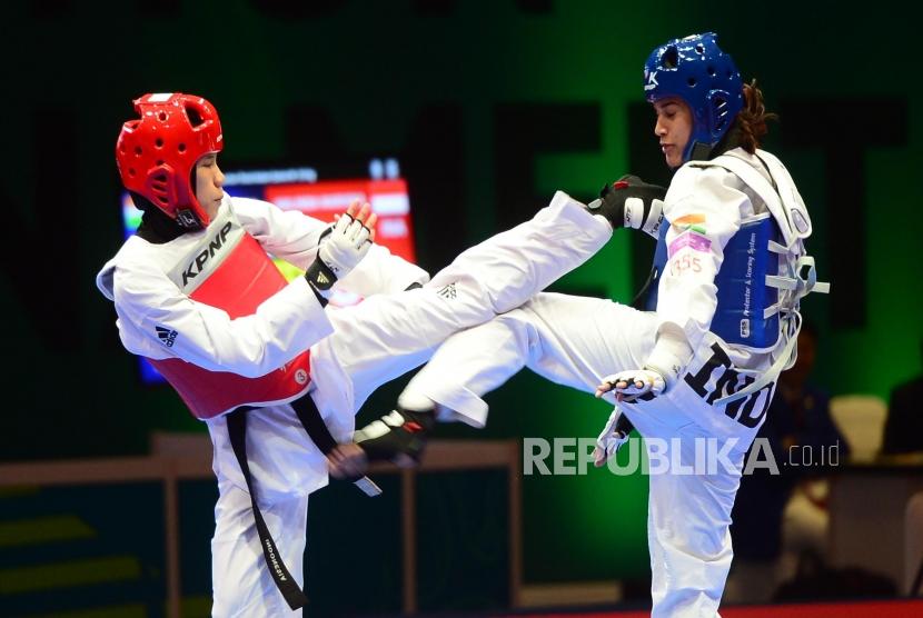 Atlet Kyorugi Taekwondo Indonesia Mariska Halinda (merah) melakukan serangan kepada lawannya Latika Bhandari (biru) dari India pada babak perempat final pertandingan Taekwondo kelas kyorugi under 53 kg, pada event Invitation Torunament Asian Games 18 di Jakarta, Sabtu (10/2).
