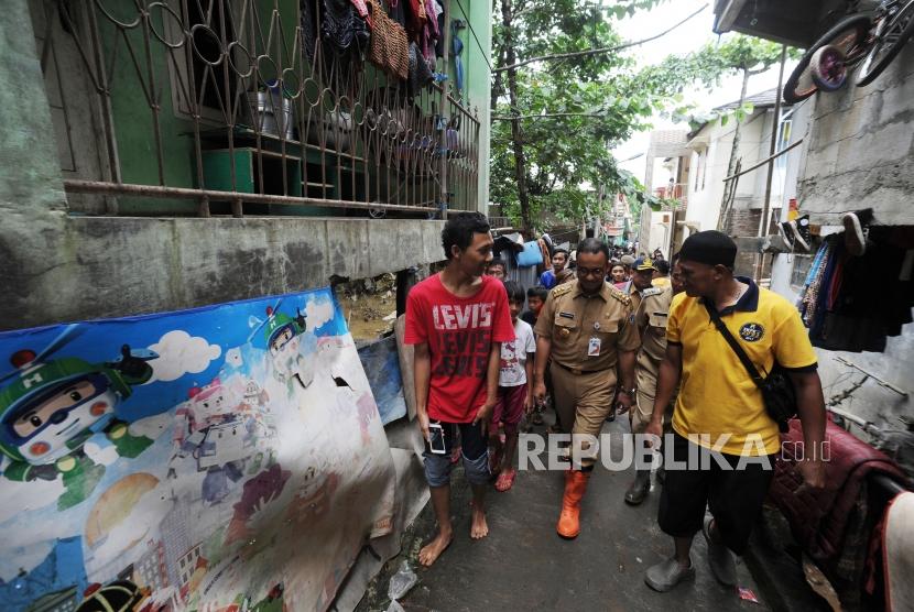 Gubernur DKI Jakarta Anies Baswedan(tengah) melakukan peninjauan ke wilayah yang terkena banjir di Gang Arus, Cawang, Jakarta Timur, Selasa (6/2).