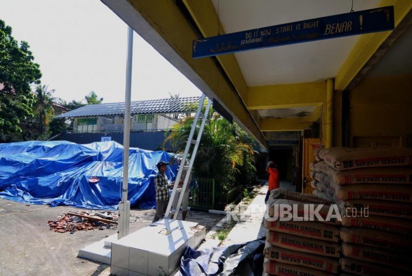 Rehabilitasi Sekolah. Pekerja melakukan perbaikan sekolah yang rusak di SDN 04 Cawang, Jakarta Timur, Selasa (31/10).