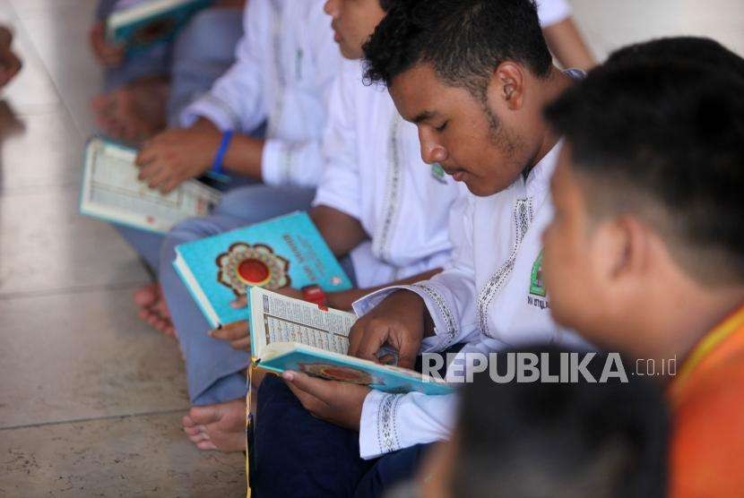Seorang pelajar membaca Alquran seusai salat Jumat di Masjid Istiqlal, Jakarta, Jumat (31/8).