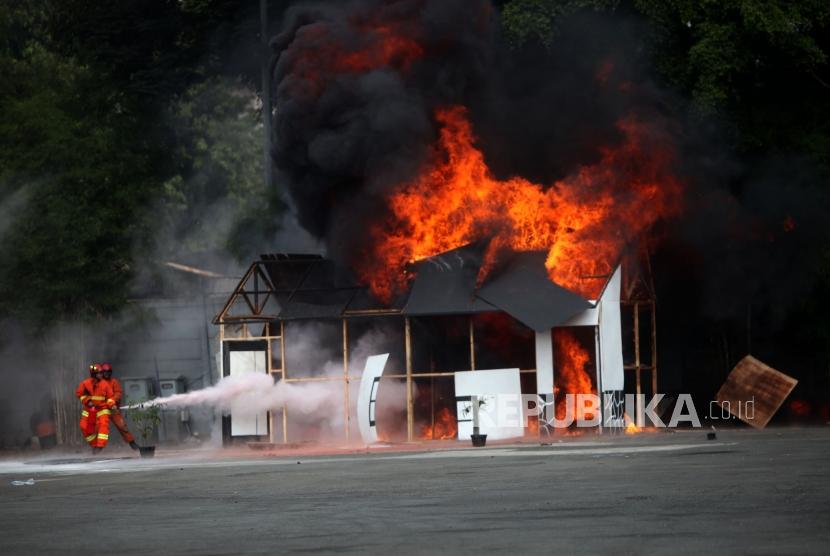 Petugas pemadam kebakaran memadamkan api saat simulasi penanganan aksi terorisme di JIExpo Kemayoran, Jakarta, Rabu (25/7).