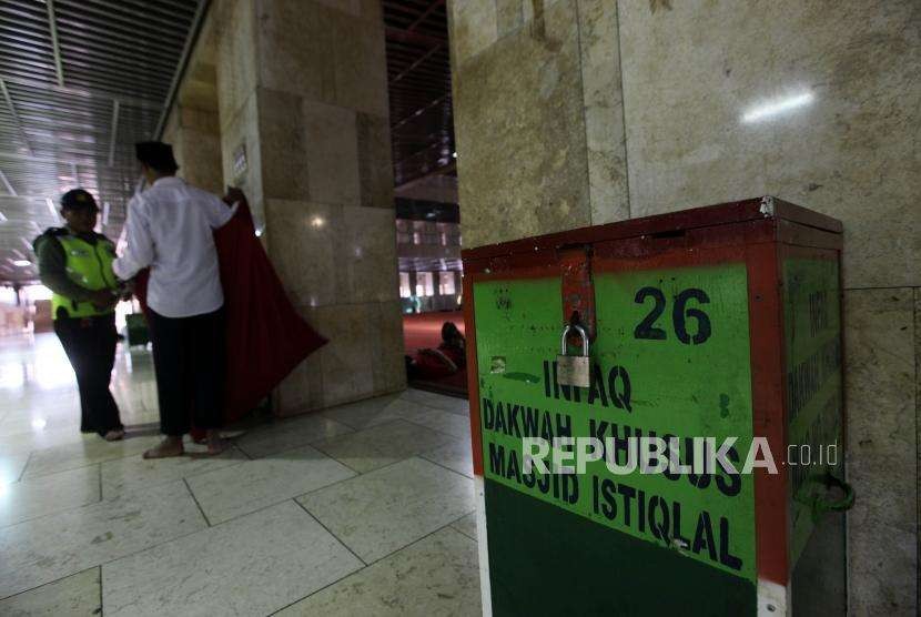 Petugas memindahkan uang infaq dari kotak amal seusai salat Jumat di Masjid Istiqlal, Jakarta, Jumat (31/8).