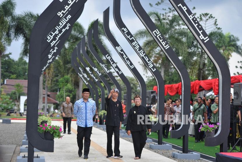 Presiden Joko Widodo (tengah) berjalan didampingi Gubernur Jawa Barat Ridwan Kamil (kiri) dan Plt Bupati Cianjur Herman Suherman (kanan) saat meninjau Alun-alun kota Cianjur, Jawa barat, Jumat (8/2).