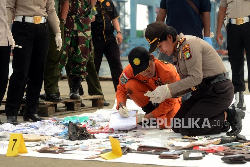 Sejumlah petugas gabungan mengidentifikasi kartu identitas yang diduga milik para korban jatuhnya pesawat Lion Air JT610 di Dermaga JICT 2 Pelabuhan Tanjung Priok, Jakarta, Selasa (30/10).