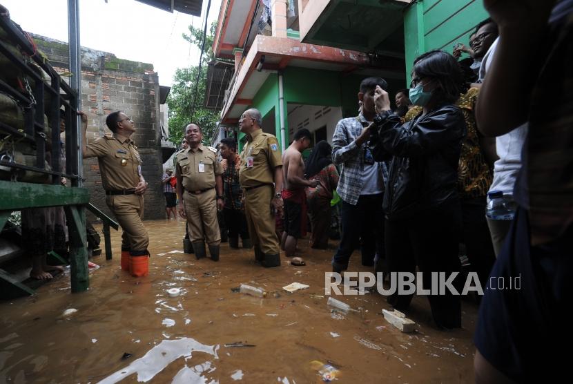 Gubernur DKI Jakarta Anies Baswedan(kiri) melakukan peninjauan ke wilayah yang terkena banjir di Gang Arus, Cawang, Jakarta Timur, Selasa (6/2).